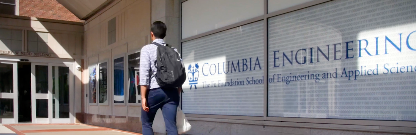 A student walking towards a Mudd Building entrance.